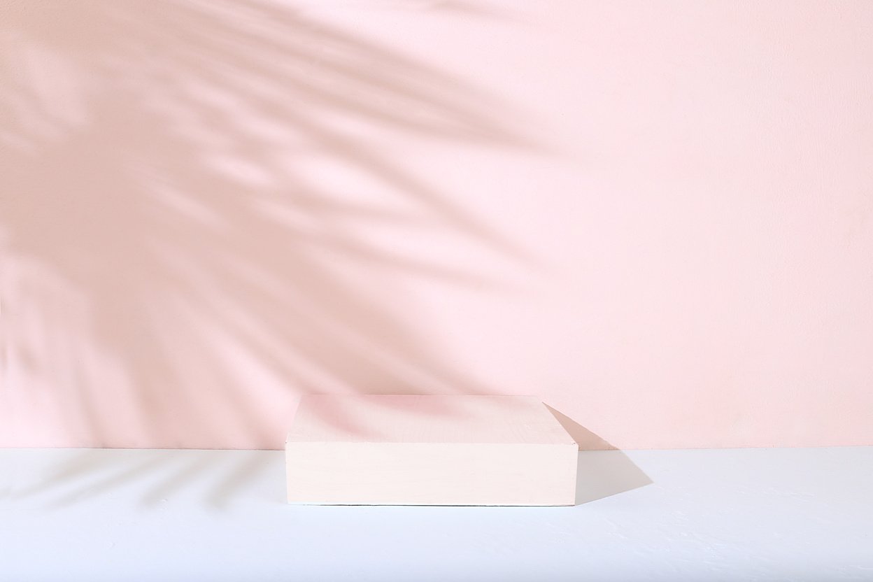Abstract background with natural wooden podiums and long shadows on a pink wall, an empty showcase for cosmetic products demonstration or presentation,